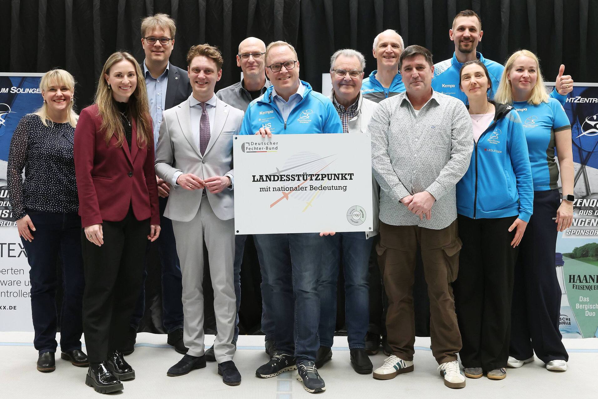 Gruppenfoto von zehn Personen, die ein Schild mit der Aufschrift „LANDESSTÜTZPUNKT mit sportlicher Bedeutung“ halten.